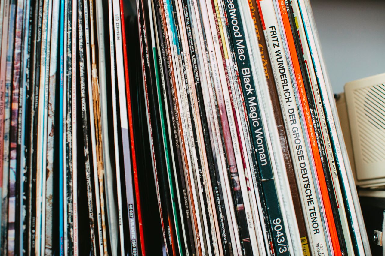 Stack of classic vinyl records neatly arranged on a shelf indoors.